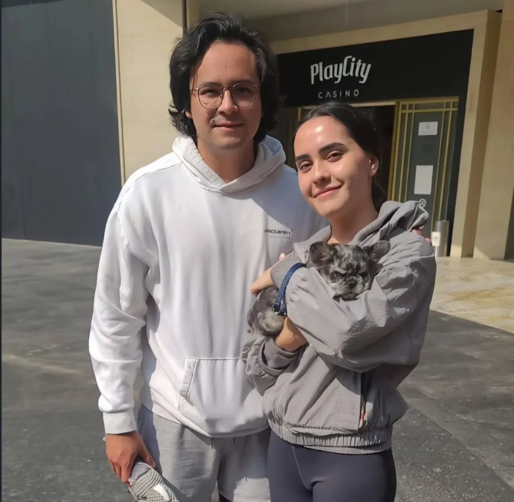 Pareja feliz con su Bulldog Francés fluffy blue merle