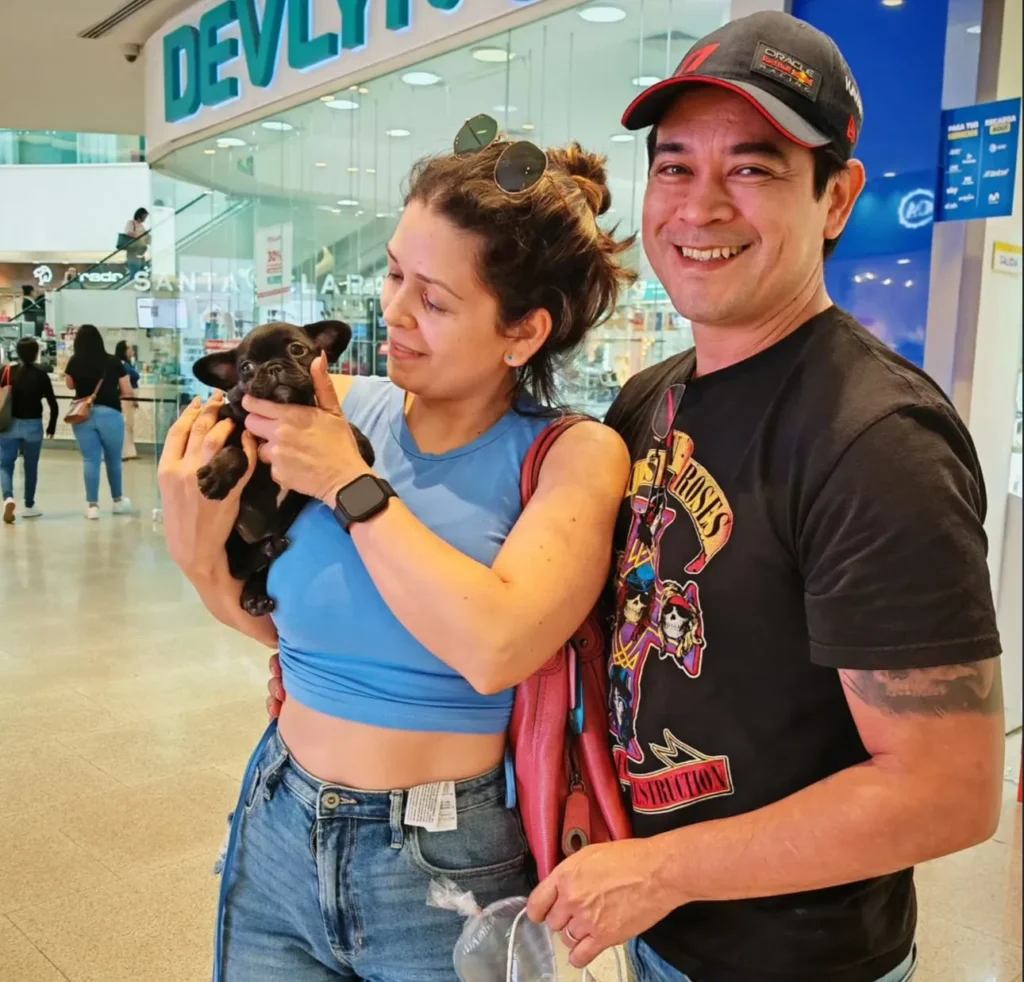 Pareja feliz con su cachorro Bulldog Francés negro